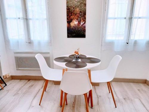 uma mesa e cadeiras num quarto com uma pintura em Appartement cosy centre-ville. em Perpignan