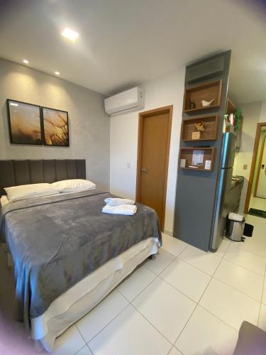 a bedroom with a large bed and a refrigerator at Mana Beach Experience Muro Alto C219 in Porto De Galinhas