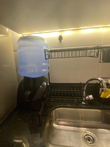 a kitchen sink with a plastic container on a drying rack at Mana Beach Experience Muro Alto C219 in Porto De Galinhas
