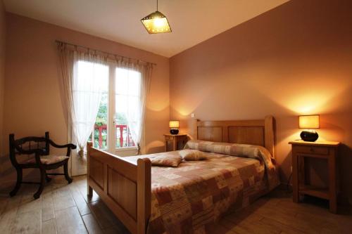 een slaapkamer met een bed, een stoel en een raam bij Juanttipienea in Souraïde