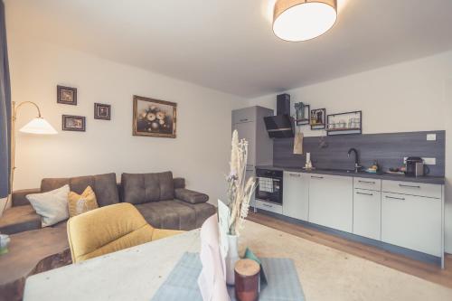 a living room with a couch and a kitchen at Anna Pertl - lieblingsquartier in Sankt Gilgen