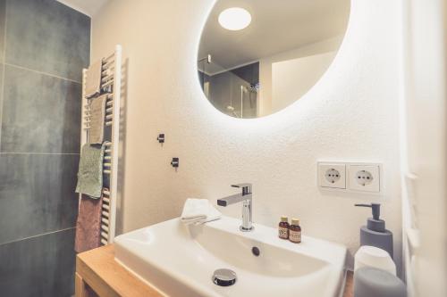 a bathroom with a sink and a mirror at Anna Pertl - lieblingsquartier in Sankt Gilgen