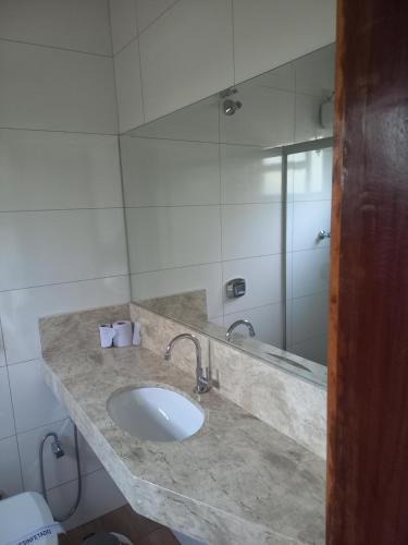 W łazience znajduje się umywalka i lustro. w obiekcie Pousada Rural Veredas w mieście Três Marias