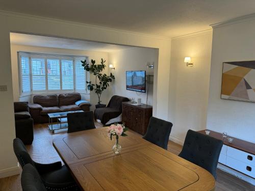 sala de estar con mesa de madera y sillas en 3 Bedroom House with Garden in London en Cheam