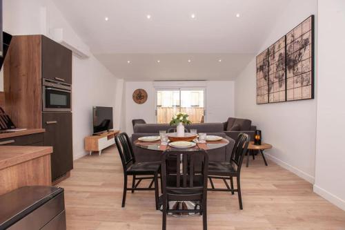 Il comprend une cuisine et un salon avec une table et des chaises. dans l'établissement Appartement avec terrasse, à Libourne