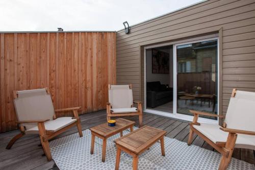2 Stühle und ein Couchtisch auf einer Terrasse in der Unterkunft Appartement avec terrasse in Libourne
