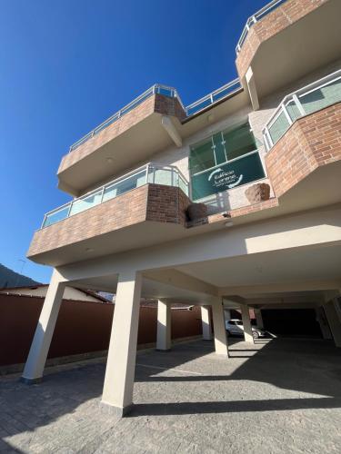 a building with a balcony on top of it at Edifício Lorenzi - Suítes & Aparts in Ubatuba