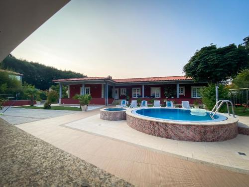 a swimming pool with chairs and a house at Turisalves- Ponte de Lima in Ponte de Lima
