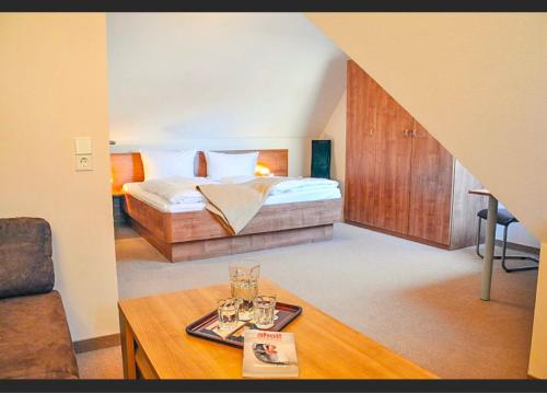 ノルダーナイにあるFischer Hausのベッドルーム1室(ベッド1台、テーブル、グラス付)