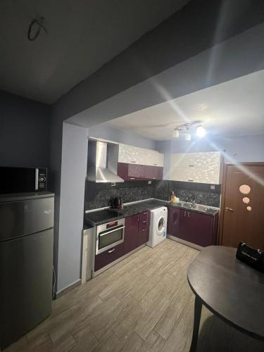 普羅夫迪夫的住宿－Многостаен Апартамент，厨房配有紫色橱柜和桌子