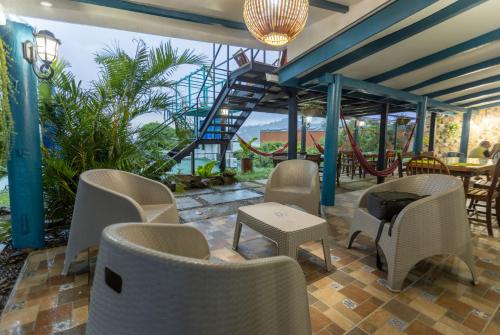 a patio with chairs and tables and a staircase at Hostel SaltWater in San Juan del Sur