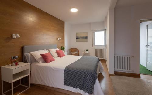 艾斯特拉達的住宿－APARTAMENTO BIENESTAR，一间卧室配有带白色床单和红色枕头的床。