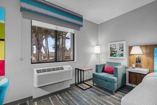 a hotel room with a bed and a chair and a window at Hampton Inn Morro Bay in Morro Bay