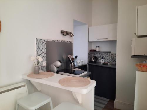 - une cuisine avec un comptoir blanc dans une pièce dans l'établissement Le studio d'en O, Au cœur de la haute ville de Pornic., à Pornic