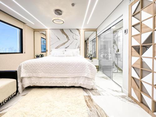 um quarto com uma cama grande e uma cabina de duche ao nível do chão em FLAT IX- Bourbon Convention Ibirapuera em São Paulo