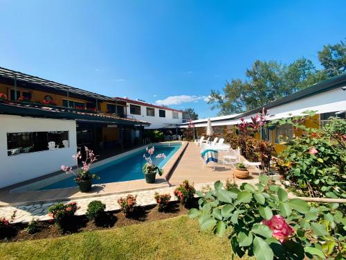 a resort with a swimming pool and some plants at Hotel Puerta del Sol - San Jose Airport in San José