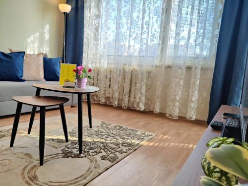 een woonkamer met een tafel en een bank bij Musninkų apartment near Akropolis in Vilnius