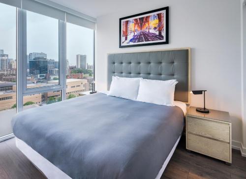 1 dormitorio con 1 cama grande y ventanas grandes en Level Chicago Old Town, en Chicago