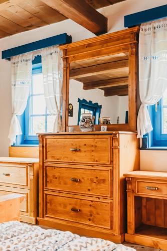a bedroom with a wooden dresser and a mirror at Lazar Guesthouse in Şiclod