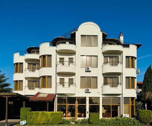a tall white building with a lot of windows at Семеен хотел"Свети Георги" in Burgas City