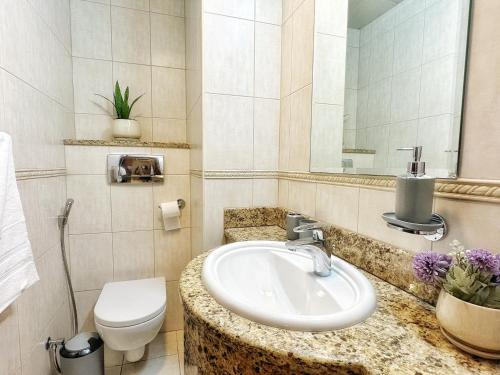 une salle de bain avec un lavabo, des toilettes et un miroir dans l'établissement Life Above Clouds, à Dubaï