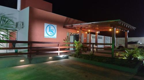 une maison avec un panneau sur son côté la nuit dans l'établissement HOTEL LA SIERRA, à Bodoquena