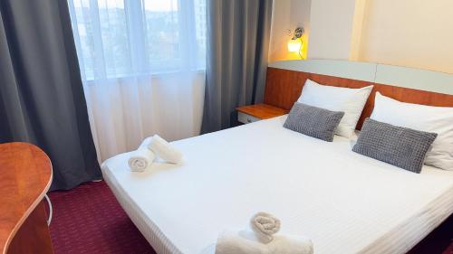 a hotel room with a bed with towels on it at Dezudava Family Hotel in Sandanski