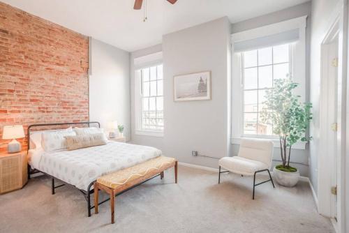 een slaapkamer met een bed en een bakstenen muur bij Relaxing, Boho Chic 2B 2Bath Downtown City View Condo in Cincinnati