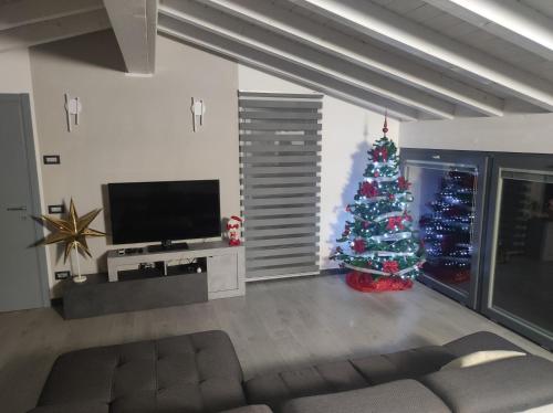 a living room with a christmas tree and a television at Luminoso appartamento vista lago in Solto Collina