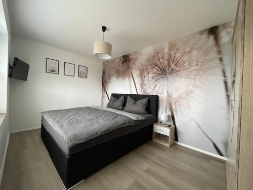 a bedroom with a bed and a large painting on the wall at Hochwertige Ferienwohnung im Bauernhaus in Freital