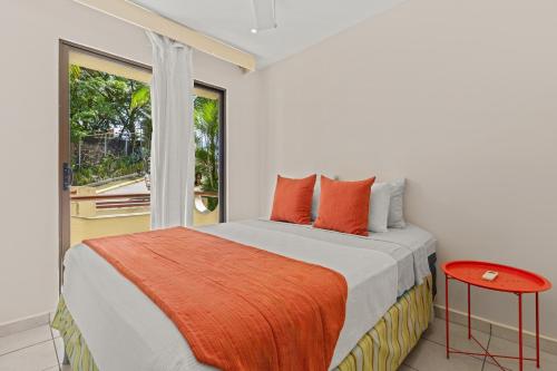 a white bedroom with a bed and a window at Beautiful beach front entire condo in Coco