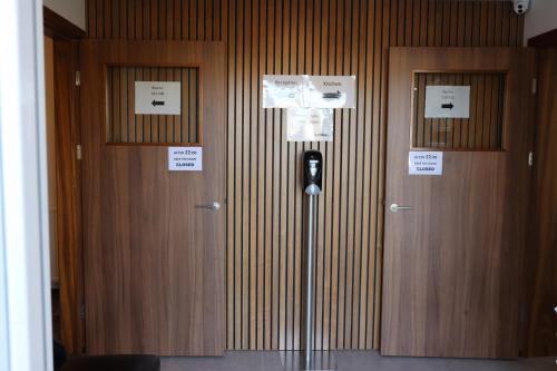 a hallway with two wooden doors with signs on them at Höfn Hostel in Höfn