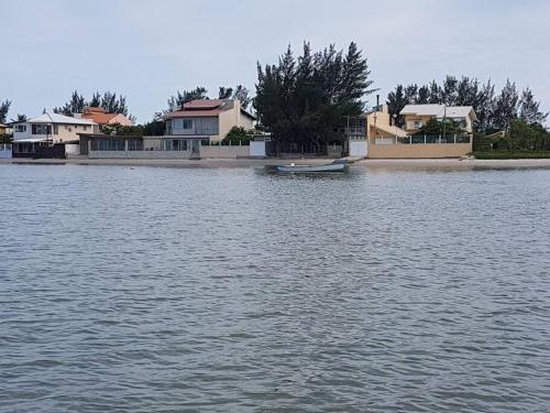 a large body of water with houses and a boat at Um lugar para relaxar in Palhoça