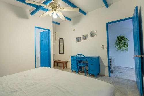 sypialnia z niebieską komodą i wentylatorem sufitowym w obiekcie Hostel SaltWater w mieście San Juan del Sur