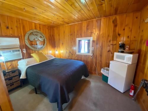 a bedroom with a bed in a wooden cabin at Cabin 8 at Horse Creek Resort in Rapid City