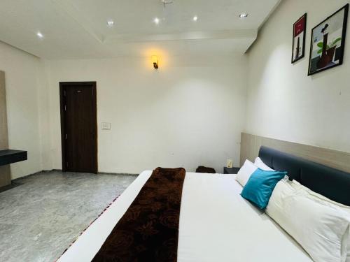 a bedroom with a large white bed with blue pillows at KRISHNA HOME STAY in Ujjain