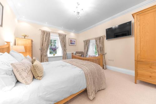 a bedroom with a bed and a tv on the wall at Gate House in Coniston