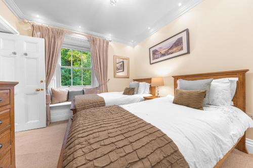 a bedroom with two beds and a window at Gate House in Coniston