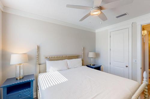 a white bedroom with a bed and a ceiling fan at Home Sweet San Blas in Cape San Blas