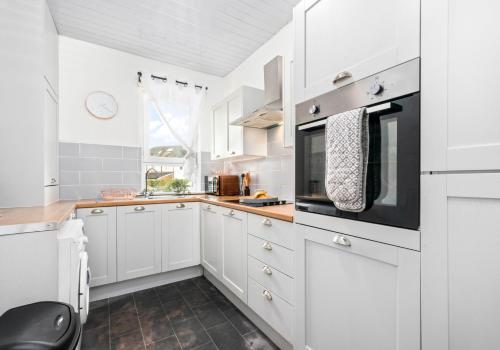 una cucina con armadietti bianchi e forno a microonde di Anderson Apartment by Klass Living Motherwell a Motherwell