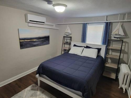 a bedroom with a bed with a blue comforter at Annapolis Escape Steps to Harbor backs to Gate 1 in Annapolis