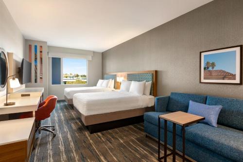 Habitación de hotel con cama y sofá en Hampton Inn & Suites San Mateo-San Francisco Airport, en San Mateo