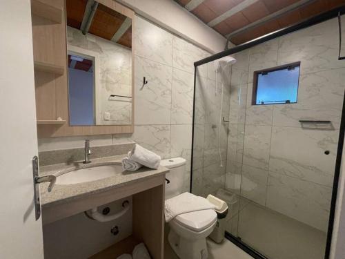 uma casa de banho com um WC, um lavatório e um chuveiro em Loft 9 entre gramado e canela em Canela