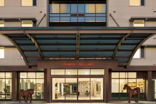 un edificio con due statue di cavalli di fronte di Hampton Inn & Suites San Mateo-San Francisco Airport a San Mateo