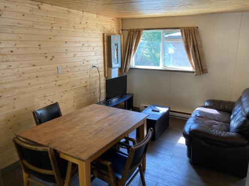 sala de estar con mesa de madera y sofá en The Hiker Huts, en Port Renfrew