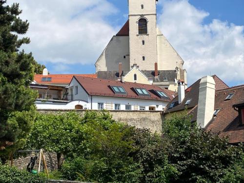 a church with a steeple on top of a building at kremsoase in Krems an der Donau