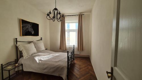sypialnia z łóżkiem z żyrandolem i oknem w obiekcie Historisches Badehaus w mieście Hoym