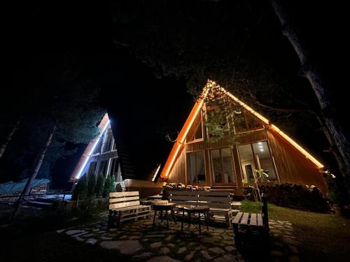 a house with lights on the front of it at night at Pine Cabins Zlatibor in Zlatibor