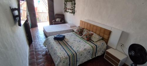 - une petite chambre avec un lit et une chaise dans l'établissement Casa Hostal Colonial VaraEchada, à Barichara