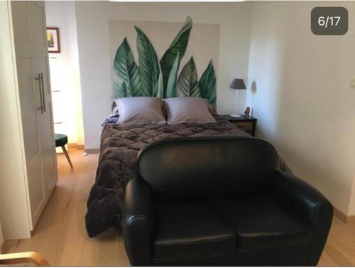 - une chambre avec un lit et un fauteuil en cuir noir dans l'établissement Studio Confort centre ville, à Bordeaux